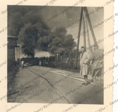 Photograph of a view of a burning hut a...