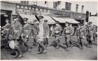 Photograph of bandsmen of the 1st Battalion, The Durham Light Infantry, marching through a city street, taken at Shanghai, China, c.1938
