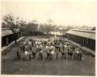 Photograph of the regimental polo ponies of the 1st Battalion, The Durham Light Infantry, and their grooms, taken at a stables in Shanghai, China, 1938