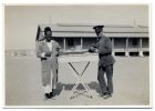 Photograph of a soldier of The Durham Light Infantry, William Lambeth, and an Egyptian standing beside a trestle table, Alexandria, Egypt, 1928