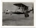 Photograph of a Royal Air Force bi-plane, flying over unidentified countryside, n.d., 1920s