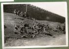 Photograph of a group of soldiers, captioned A rest, the city wall in rear [19], c.1939