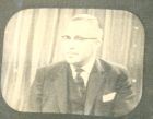 Photograph of a man [possibly retired Captain Stanley Levitt, 113th Light Anti-Aircraft Regiment, Royal Artillery (2/5th Battalion, The Durham Light Infantry)] appearing in a television programme, n.d