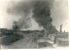 Photograph of a view of burning huts at Belsen Concentration Camp, taken in Germany, May 1945