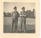 Photograph of soldier Lewis Crick, left, and Battery Sergeant-Major Stanley Levitt, right, of the 113 Light Anti-Aircraft Regiment, Royal Artillery (Territorial Army), standing in a camp, taken in Ger