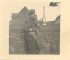 Photograph of Battery Sergeant-Major Stanley Levitt, 113 Light Anti-Aircraft Regiment, Royal Artillery (Territorial Army), standing by a wall, taken in Germany, June 1945