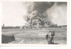 Photograph of the burning of a large section of Belsen concentration camp, Germany, 20 May 1945
