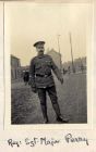 Photograph of a non-commissioned officer of the 6th Battalion The Durham Light Infantry with cane standing in a street, captioned: Reg. Sgt. Major Perry, n.d. [1914 - 1915]
