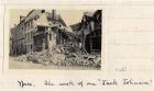Photograph of the remains of a ruined building hit by shell fire, captioned: Ypres - The work of one 'Jack Johnson', Belgium, n.d. [1915]