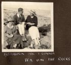 Photograph of Mrs. Ferguson, Nic, and Connie McBain having tea, sitting on rocks beside the sea at Dragonara, Malta, n.d. [ c.1919]