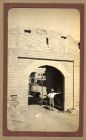 Photograph of a soldier of the 2nd Battalion The Durham Light Infantry, probably George Pinkney, standing under the arched gateway to a fort erected in 1805, India, n.d. [ c.1930]