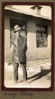 Photograph of George Pinkney, 2nd Battalion, The Durham Light Infantry, wearing a leather jerkin used for bayonet practice, outside barracks buildings at Ramzak, North West Frontier Province, India, N
