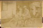 Photograph of an unidentified man in civilian dress seated on a motor cycle, probably taken in India, n.d. [ c.1900]