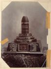 Photograph of the 'shell fired into the Indian Ordnance Field Park on 27 December 1899 as a Christmas greeting from the Boer Army Investing Ladysmith', mounted on a wooden plinth displaying a fragment