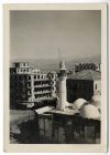 Photograph of buildings in a town, including a minaret and hills in the distance, location unknown, probably in North Africa, 1940 - 1943