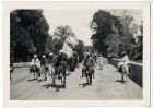 Photograph of a group of Arab men on mules, travelling on a road, with arched wall to the rear, possibly in Egypt, c.1942