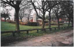 Photograph of the war memorial in context of the Village Green October 2005