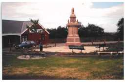 Photograph of the war memorial facing North-East and in context of the village hall June 2002